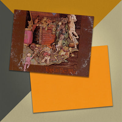 Photo of a 11” x 8.5” notebook cover made from an upcycled Aerosmith "Toys in the Attic" album sleeve and the back cover with orange cardstock on an orange, cream and grey background.