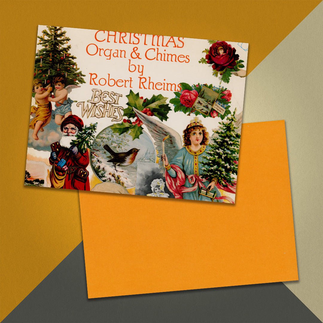 Photo of a 11” x 8.5” notebook cover made from an upcycled Robert Rheims "Christmas Organ & Chimes By Robert Rheims" album sleeve and the back cover with orange cardstock on an orange, cream and grey background.