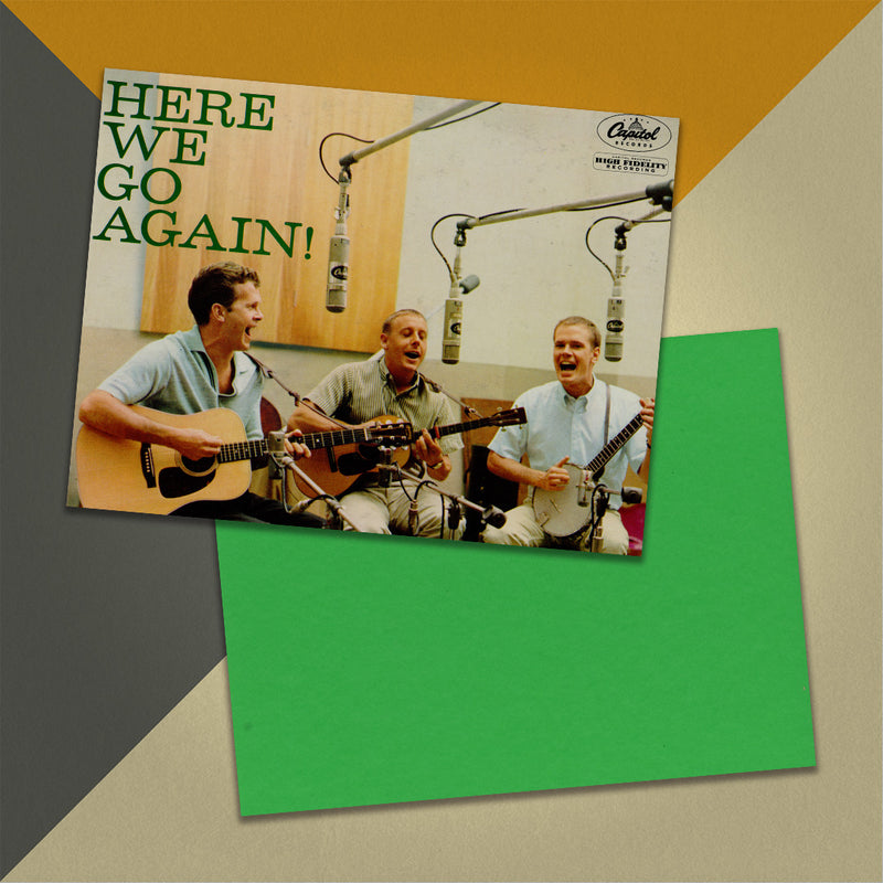 Photo of a 11” x 8.5” notebook cover made from an upcycled The Kingston Trio “Here We Go Again!” album sleeve and the back cover with green cardstock on an orange, cream and grey background.