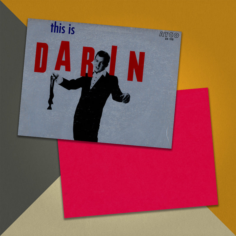 Photo of a 11” x 8.5” notebook cover made from an upcycled Bobby Darin “This is Darin” album sleeve and the back cover with red cardstock on an orange, cream and grey background.