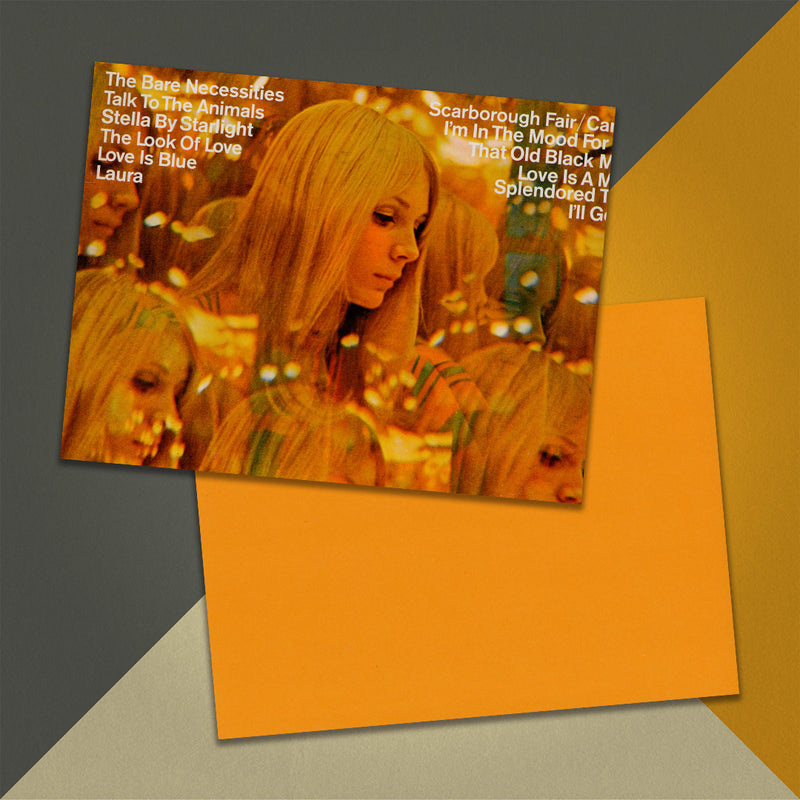 Photo of a 11” x 8.5” notebook cover made from an upcycled Andre Kostelanetz And His Orchestra “Scarborough Fair And Other Great Movie Hits” album sleeve and the back cover with orange cardstock on an orange, cream and grey background.