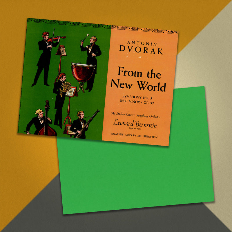 Photo of a 11” x 8.5” notebook cover made from an upcycled Antonin Dvorak : The Stadium Concerts Symphony Orchestra, Leonard Bernstein “Symphony No. 5 In E Minor, Op. 95 “From The New World”” album sleeve and the back cover with green cardstock on an orange, cream and grey background.