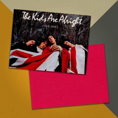 Photo of a 11” x 8.5” notebook cover made from an upcycled The Who “The Kids Are Alright” album sleeve and the back cover with red cardstock on an orange, cream and grey background.