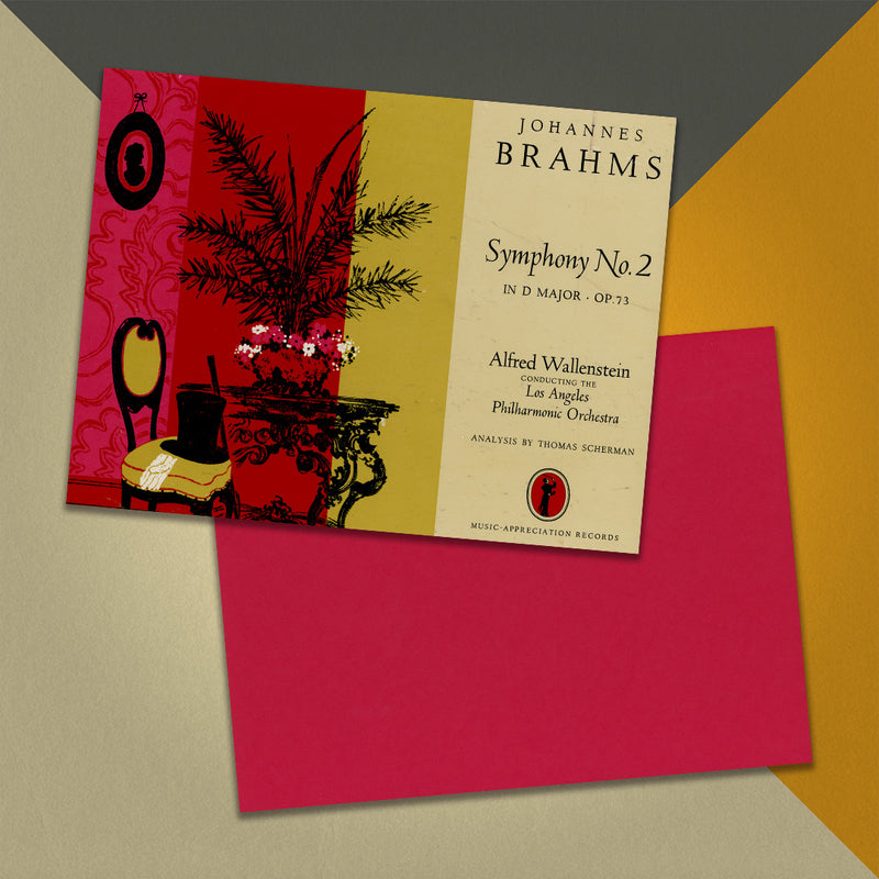 Photo of a 11” x 8.5” notebook cover made from an upcycled Johannes Brahms “Symphony No.2 In D Major - OP. 73” album sleeve and the back cover with red cardstock on an orange, cream and grey background.