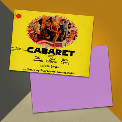 Photo of a 11” x 8.5” notebook cover made from an upcycled John Kander, Fred Ebb “Cabaret” album sleeve and the back cover with light purple cardstock on an orange, cream and grey background.