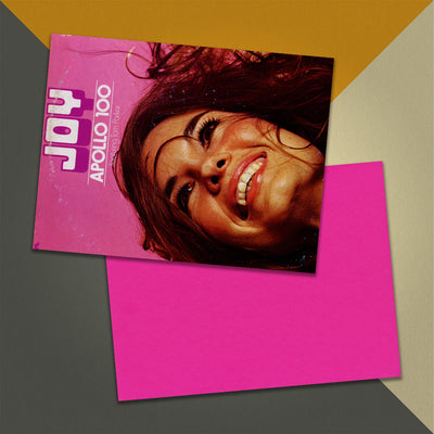 Photo of a 11” x 8.5” notebook cover made from an upcycled Apollo 100 “Joy” album sleeve and the back cover with hot pink cardstock on an orange, cream and grey background.