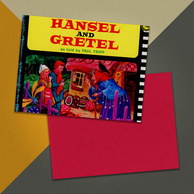 Photo of a 11” x 8.5” notebook cover made from an upcycled Paul Tripp “Hansel and Gretel” album sleeve and the back cover with red cardstock on an orange, cream and grey background.