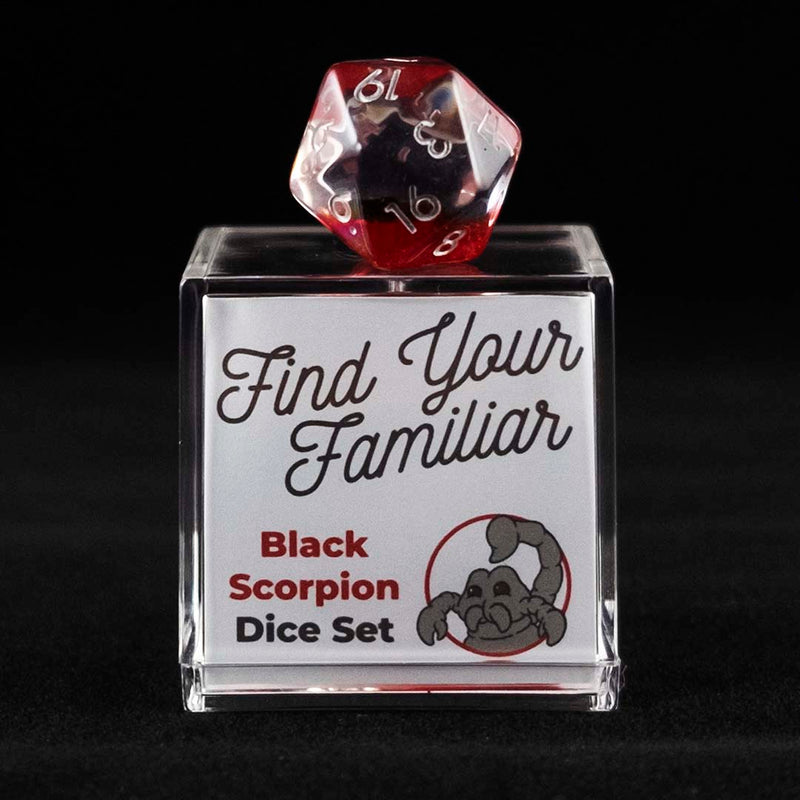 A 20 sided clear and red die with black scorpion inclusions sitting on top of a small acrylic box with the words "Find Your Familiar" and "Black Scorpion Dice Set" on a black background.