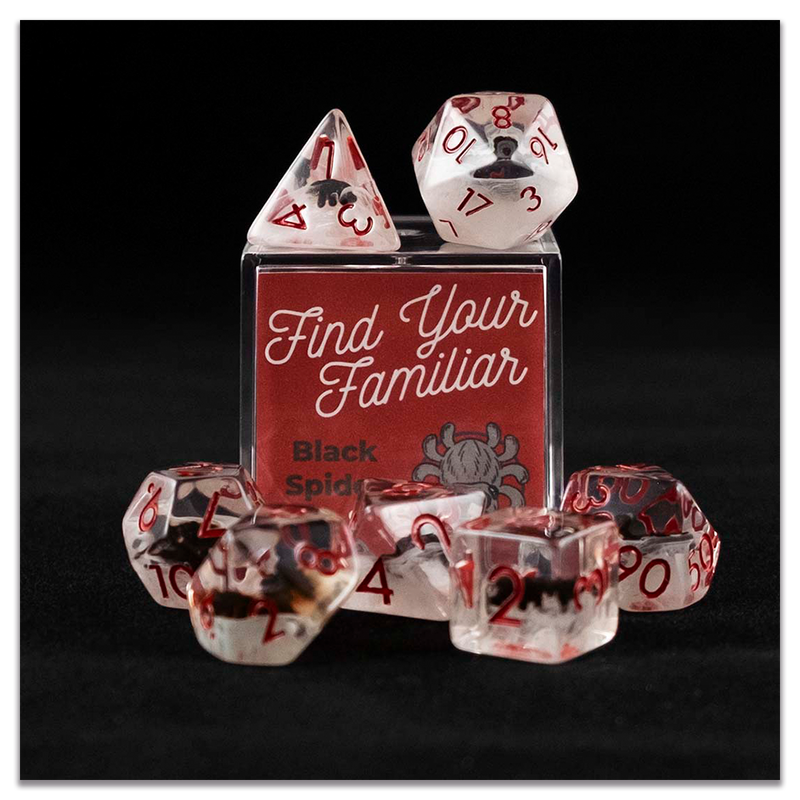 A set of clear and cloudy polyhedral dice with black spider inclusions sitting on top and around a small acrylic box with the words "Find Your Familiar" and "Black Spider Dice Set" on a transparent background.