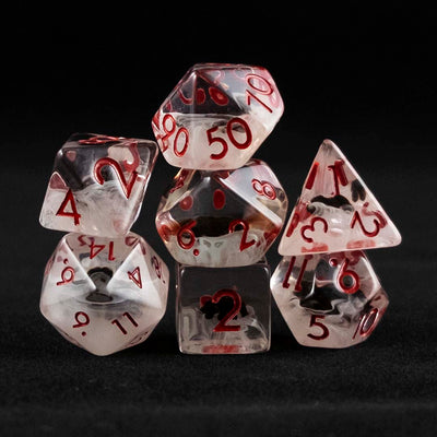 A set of clear and cloudy polyhedral dice with black spider inclusions on a black background.