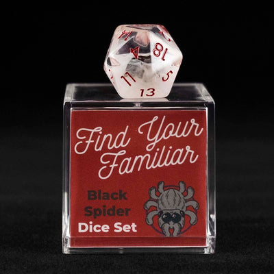 A 20 sided clear and cloudy die with black spider inclusions sitting on top of a small acrylic box with the words "Find Your Familiar" and "Black Spider Dice Set" on a black background.