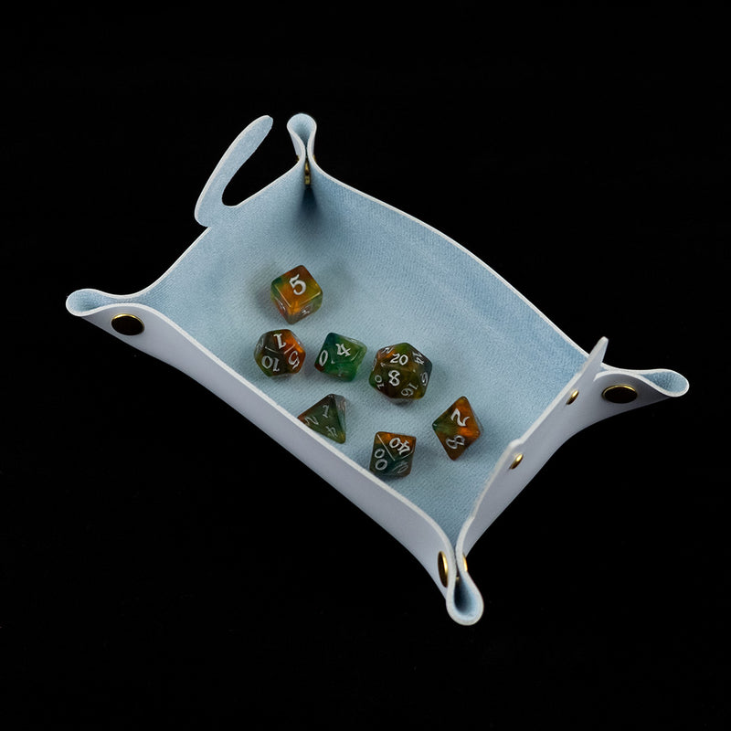 Photo of a blue cat shaped dice tray from above with a set of dice inside on a black background.