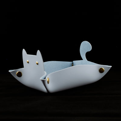 Photo of a blue cat shaped dice tray facing left on a black background.