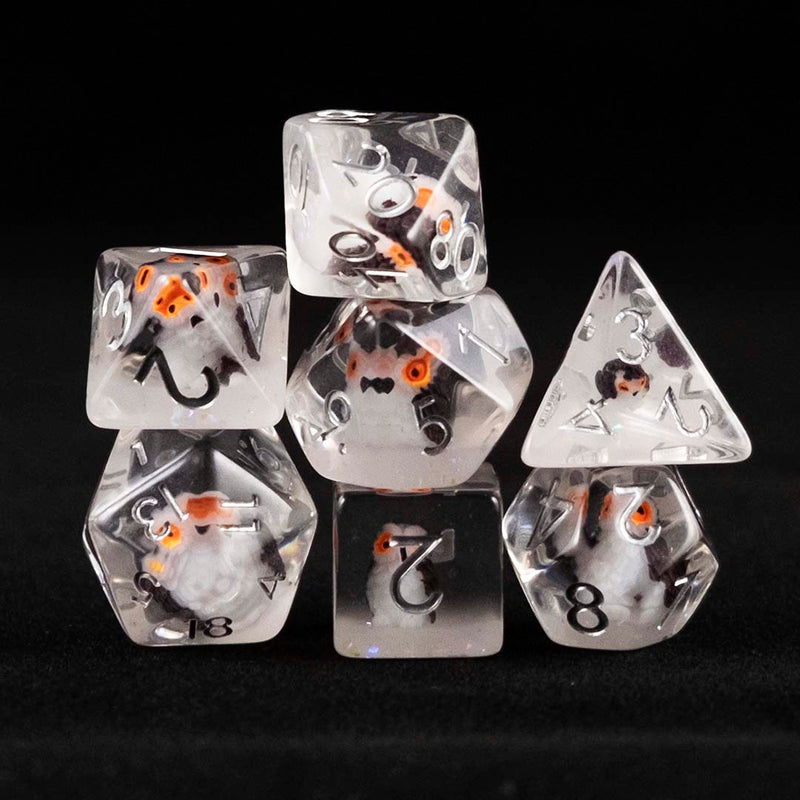 A set of clear polyhedral dice with grey owl inclusions on a black background.