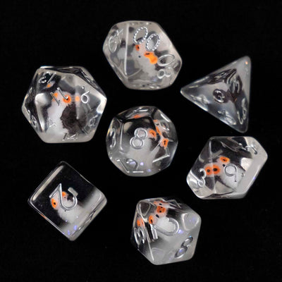 A set of clear polyhedral dice with grey owl inclusions from above on a black background.