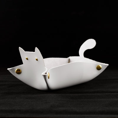 Photo of a grey cat shaped dice tray facing left on a black background.