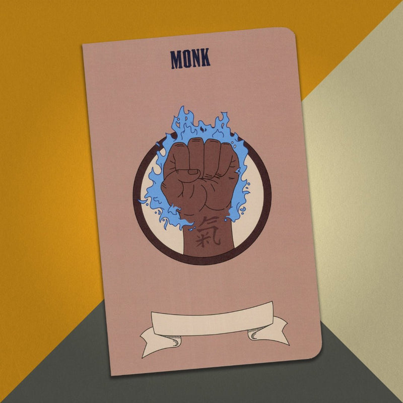 A large monk notebook with a light brown cover and an illustration of a fist surrounded by blue flames on an orange, cream and grey background.