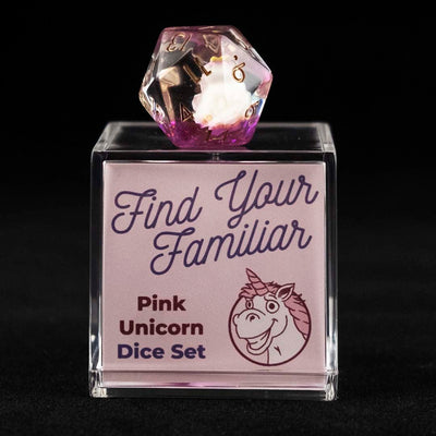 A 20 sided clear and purple die with pink unicorn inclusions sitting on top of a small acrylic box with the words "Find Your Familiar" and "Pink Unicorn Dice Set" on a black background.