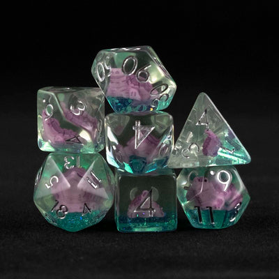 A set of clear green polyhedral dice with purple turtle inclusions on a black background.