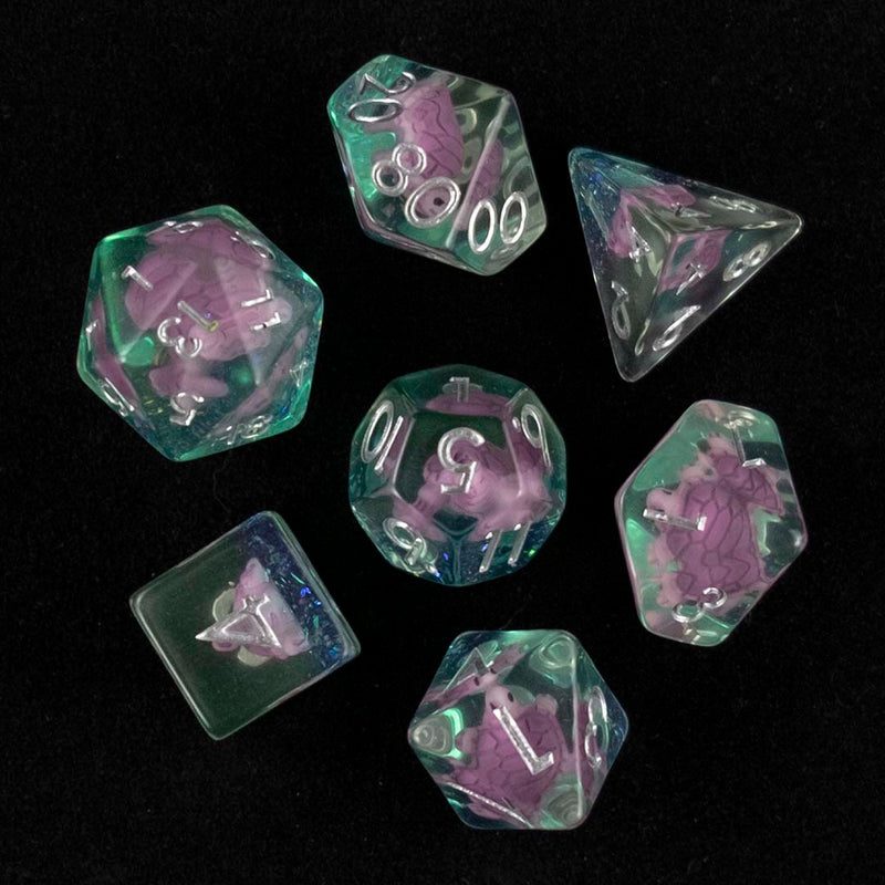 A set of clear green polyhedral dice with purple turtle inclusions from above on a black background.