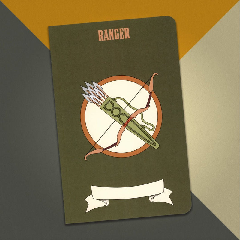 A large ranger notebook with a dark green cover and an illustration of a bow and a quiver of arrows on an orange, cream and grey background.