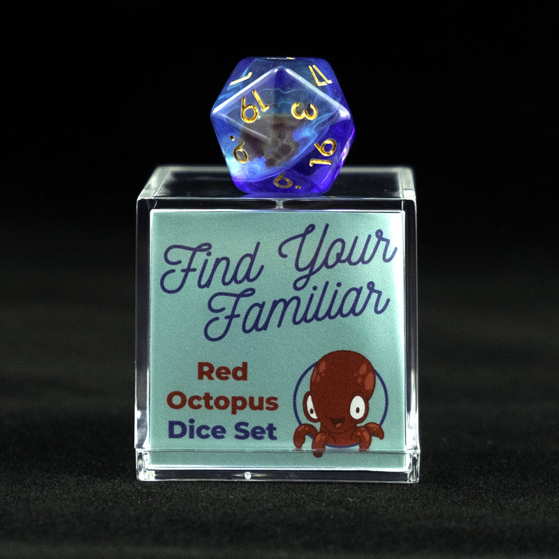 A 20 sided clear green and blue die with red octopus inclusions sitting on top of a small acrylic box with the words "Find Your Familiar" and "Red Octopus Dice Set" on a black background.