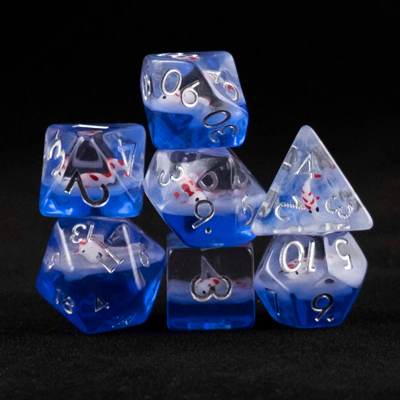 A set of clear and blue polyhedral dice with red and white koi inclusions  on a black background.